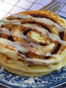 Cinnamon Roll Pancakes on a blue and white toile plate.
