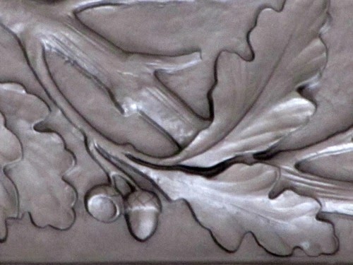Close-up of an acorn and its leaves, details on the ceiling. 