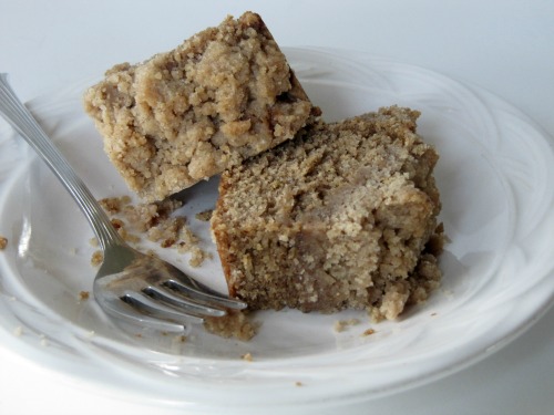Two slices of Crumb Lovers coffee cake on a white plate with a fork.