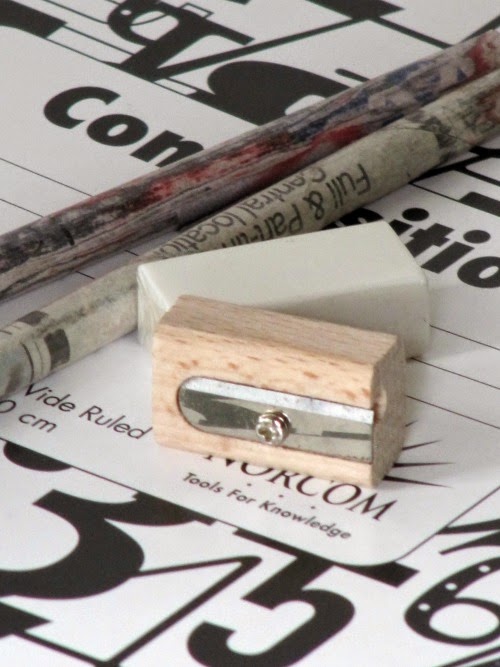 wood pencil sharpener and pencils laying on a composition book