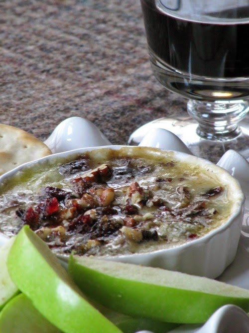 Baked Cambozola cheese in a ramekin, apples and a glass of wine. 