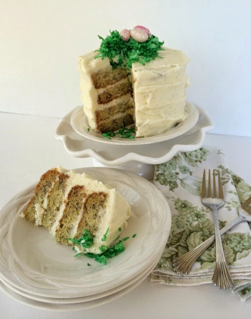 Banana Cake with whipped cream cheese frosting sliced on a white plate. 