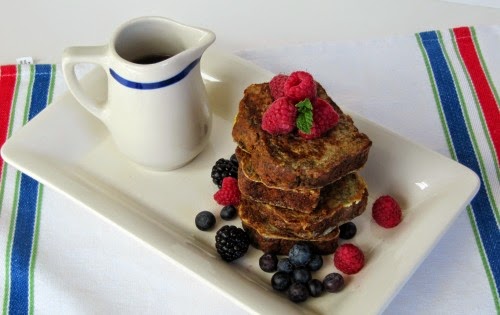 French Toast on a white platter with berries. 