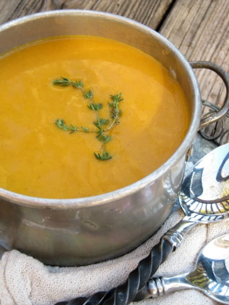 roasted-butternut-squash-soups with thyme and herbs in a silver pot with a spring of thyme