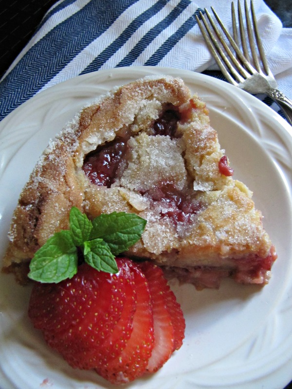 Fresh Strawberry cake with a fresh strawberry on the side of the white plate. 