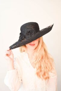 Woman wearing a black Kentucky Derby Hat. 