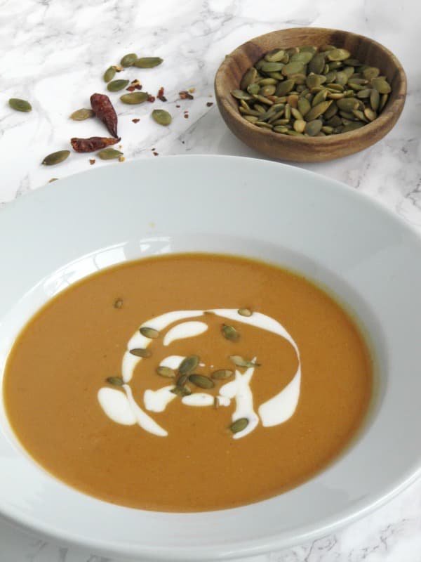 bowl of fall pumpkin ginger soup with Greek yogurt swirl