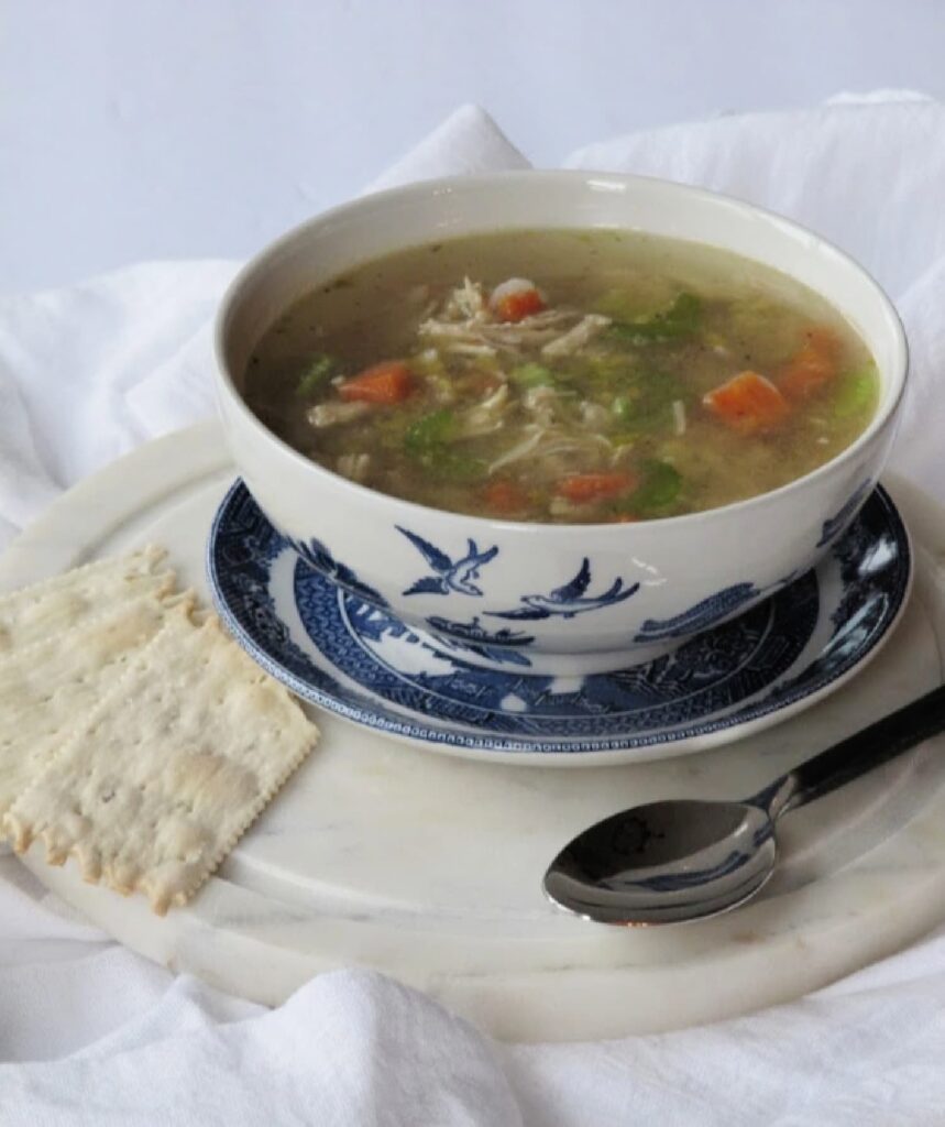 chicken noodle soup in a blue and white bowl