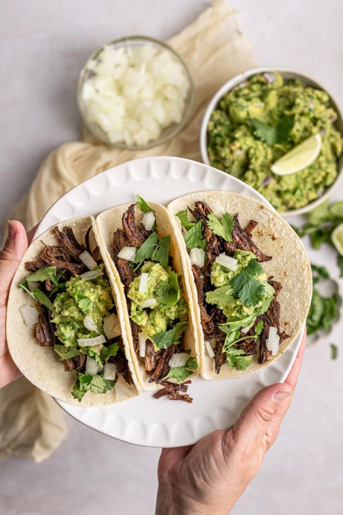 Barbacoa tacos on a plate. 