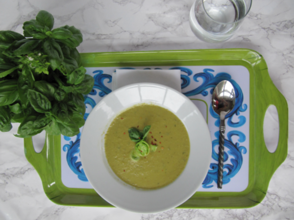 roasted green tomato soup in a white bowl in a green and blue tray. 