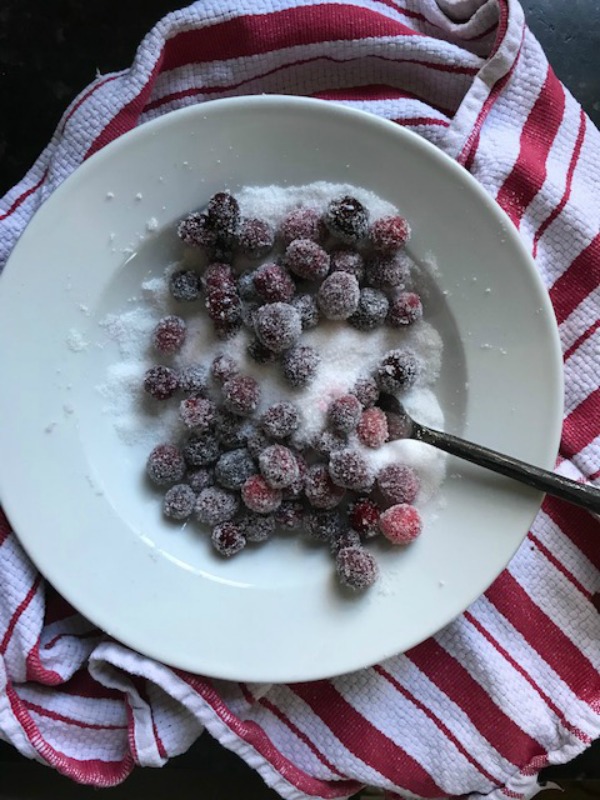 Cranberries tossed in sugar in a white bowl