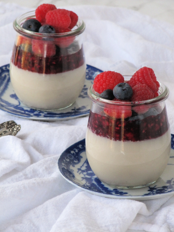 Almond milke Panna Cotta with berry coulis on blue plates