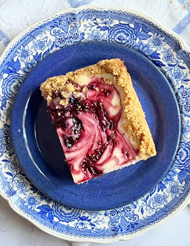 blackberry Swirl Cheesecake bars on a blue and white transferware plate