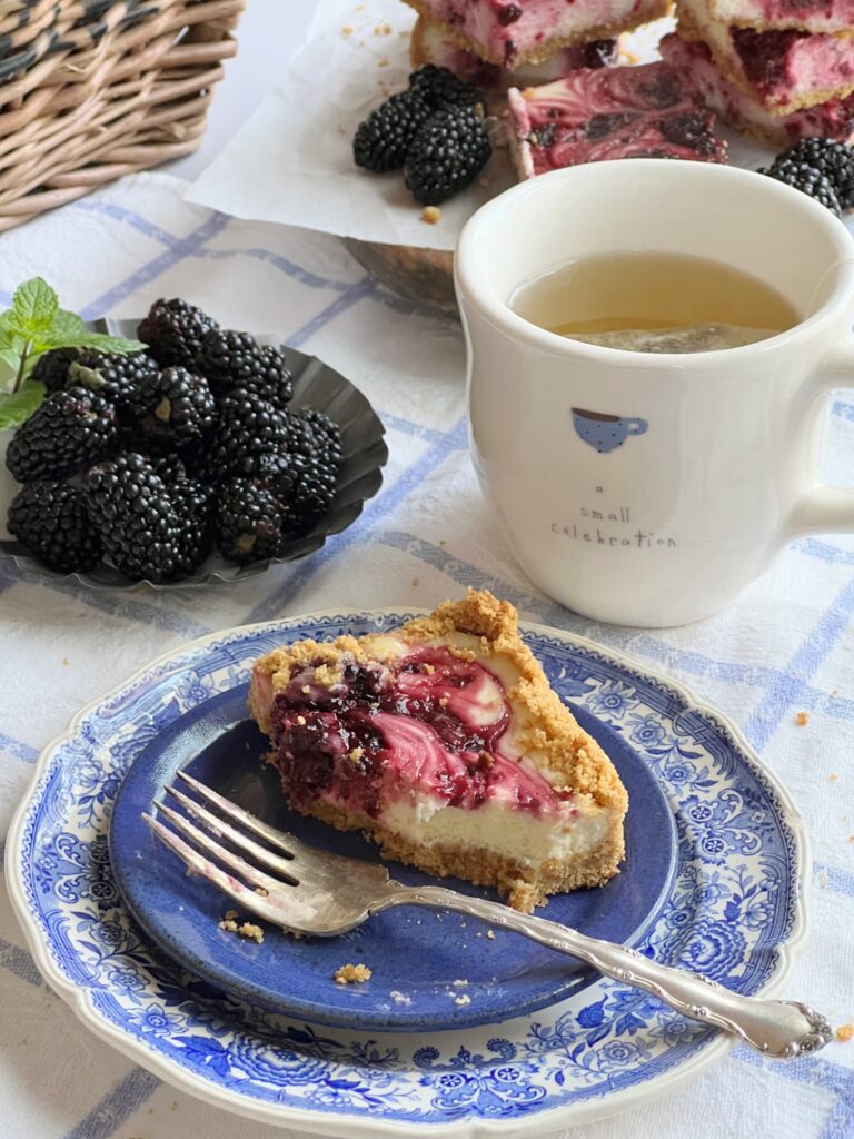slice of blackberry swirl cheesecake and a cup of tea