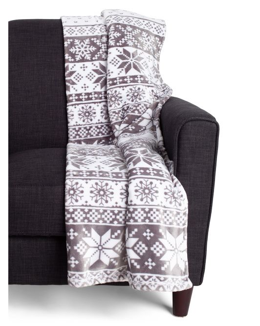 Gray and white fleece snowflake throw draped over a couch