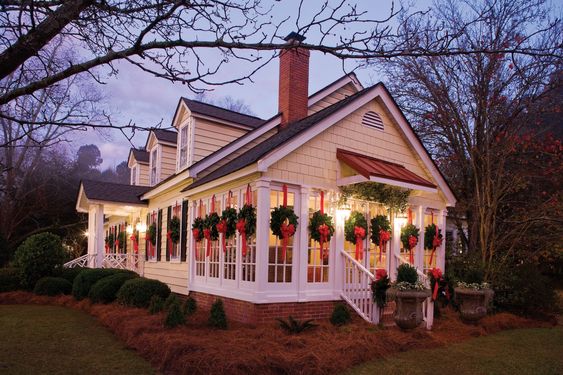 Small White House with a Christmas wreath on every window