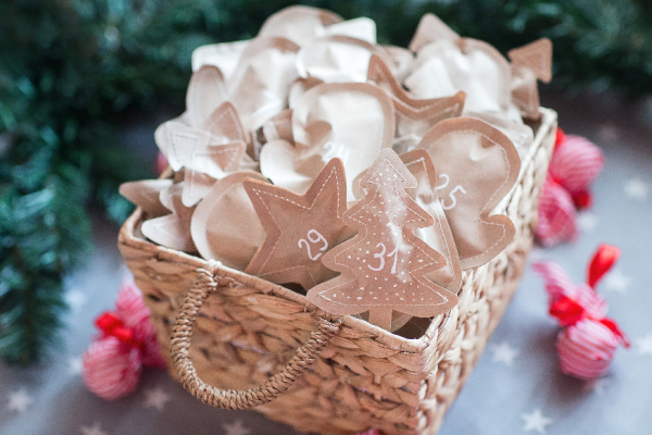 a basket of brown paper packages numbered 1-25 for advent
