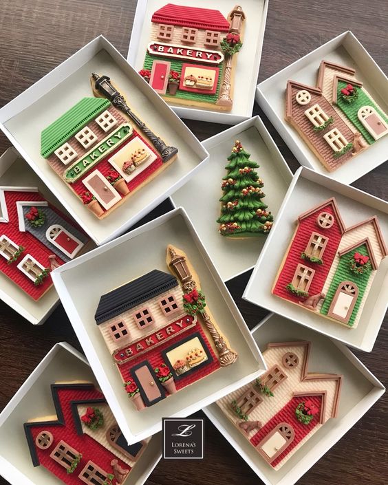 decorated christmas sugar cookies shaped like houses and trees set on white plates