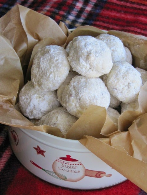 christmas tin filled with round cookies covered in powdered sugar