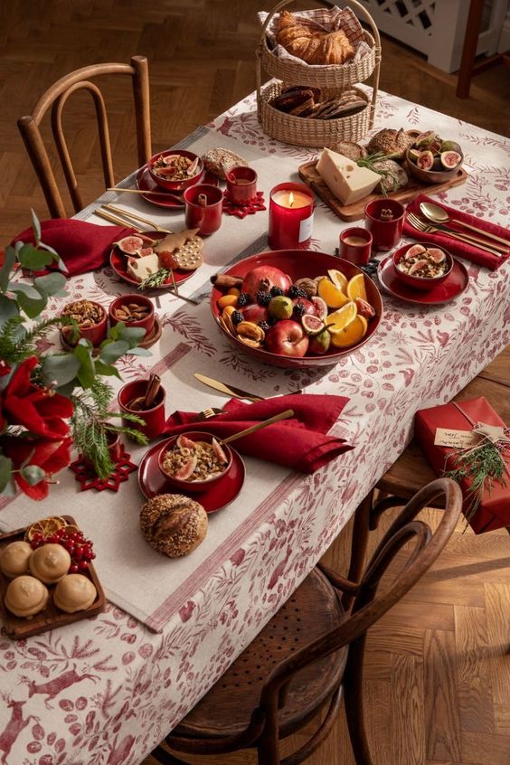 a burgundy and white tablecloth on a table laden with christmas food
