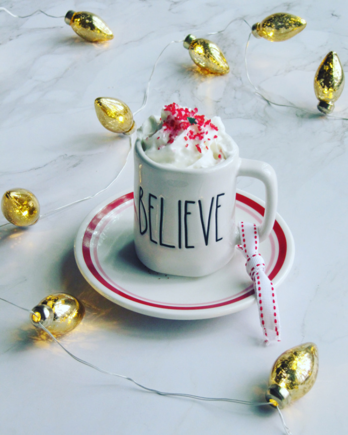 Believe Cup of hot chocolate with sprinkles and gold christmas lights