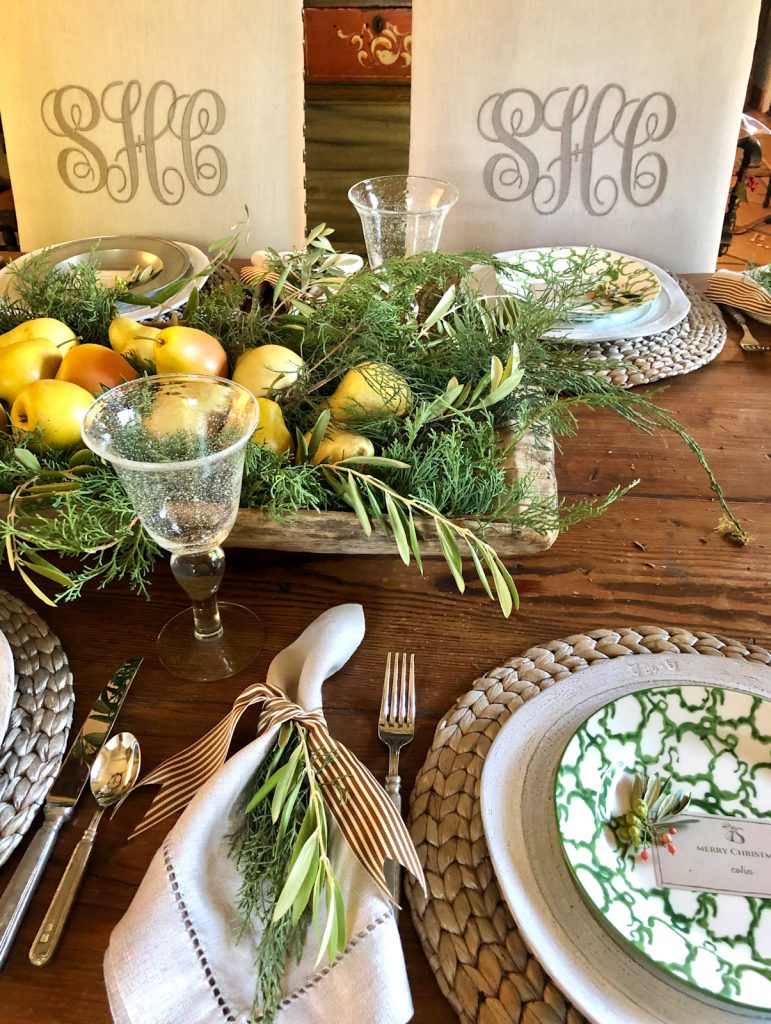 tablescape for the holidays with a dough bowl filled with greens and pears