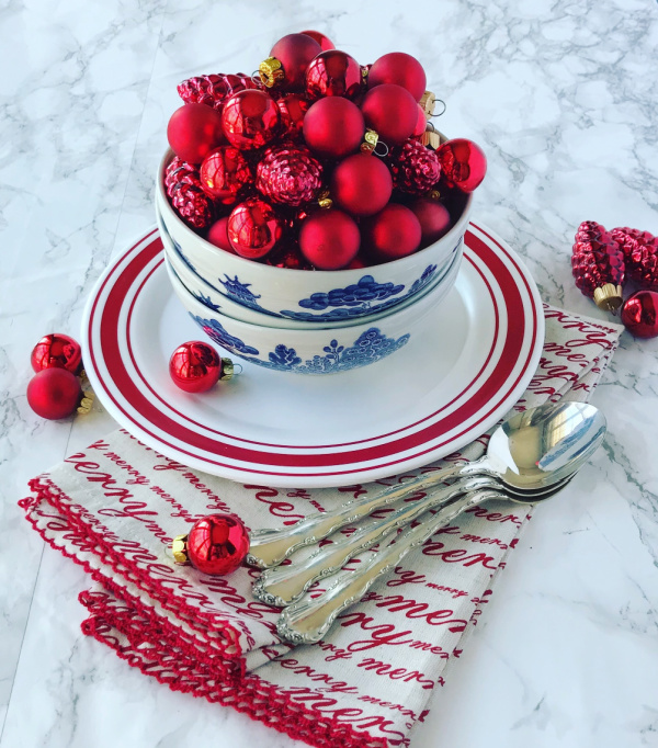blue willow china bowls filled with red christmas bulbs
