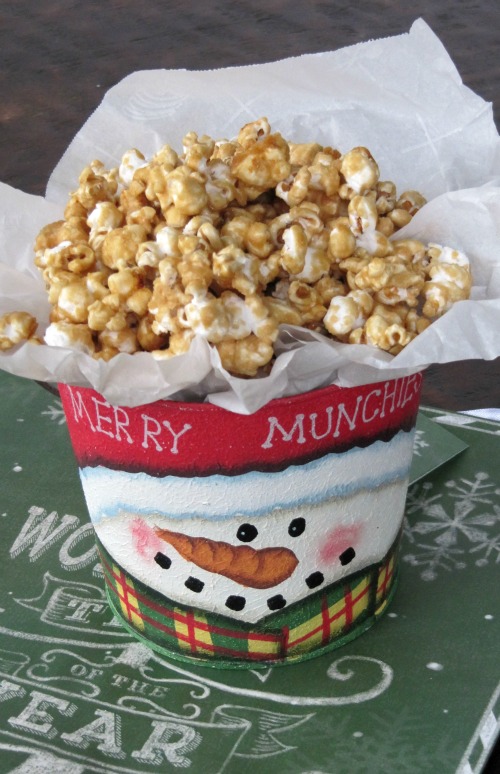 15 Ways to Spread Joy Through the Holidays, small metal bucket painted with a snowman and filled with caramel corn. 