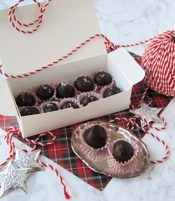 fleur de sel truffles in a white box sitting on a piece or red tartan paper with red and white string