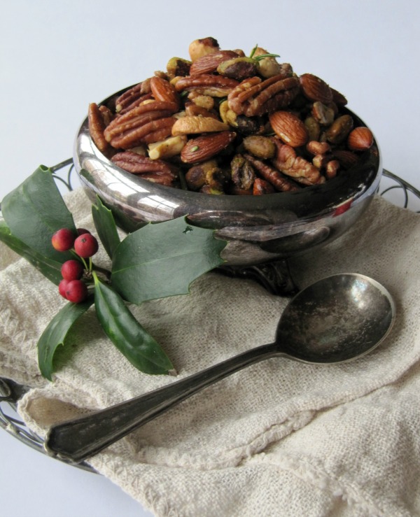 A silver bowl filled with mixed nuts on a tray