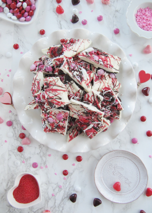 Valentines Day Chocolate Bark with various containers of sprinkles and candy