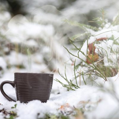 brown mugs of chocolate in the snow