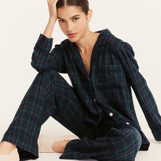woman sitting on the floor in black watch plaid pajamas