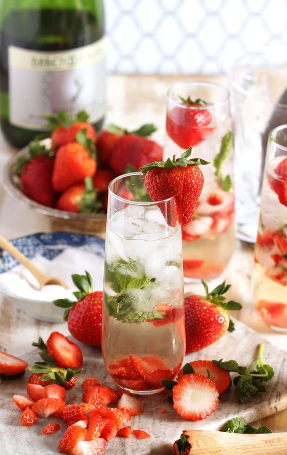 strawberry mojito with bowls of strawberries and sugar