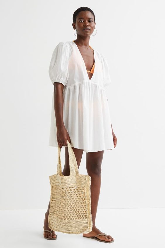 Monday meanderings Woman wearing a white cover up and holding a straw bag