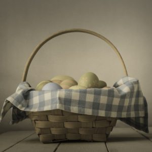 Monday Musings wicker basket with a gingham napkins filled with easter eggs