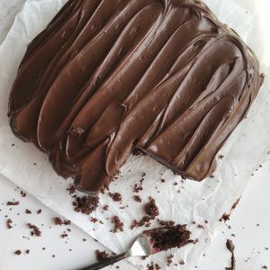 Chocolate snack cake with Hershey's chocolate frosting on parchment paper