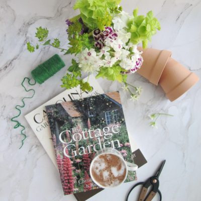 Friday Favorites flatlay with terracotta pots garden books sizzors and twine