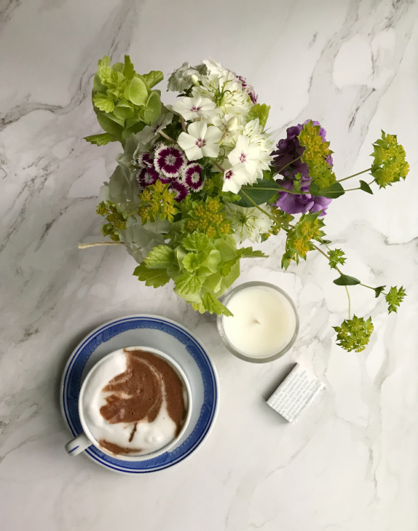 Spring wild flowers in a jar hot chocolate and a candle flatlay