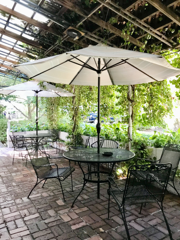 Friday Favorites The Pinecrest vine covered pergola with umbrellas and iron chairs