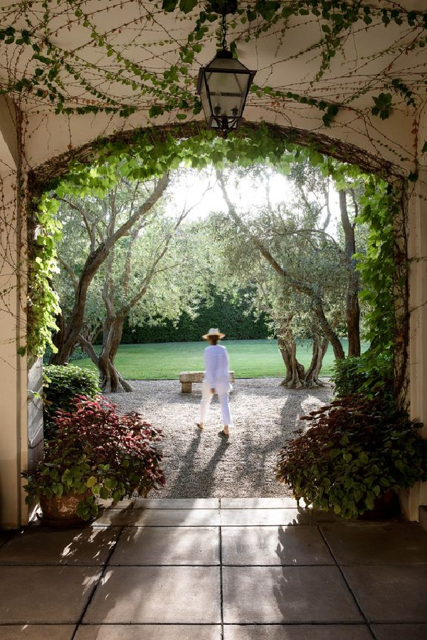 Weekend Meanderings Woman standing under a vine covered arch