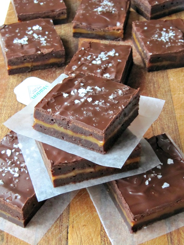 a pile of chocolate caramel brownies sprinkled with sea salt