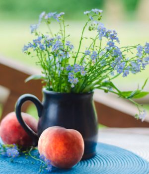 wildflowers in a brown pitcher and peaches