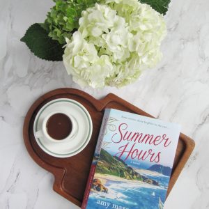 flatlay hydrangeas cup of hot chocolate and a book on a wood board