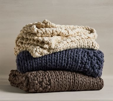 a stack of throws, tan, blue and brown