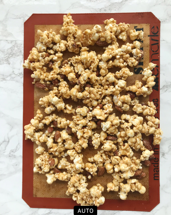 Cooling caramel corn on a silphat baking mat. 