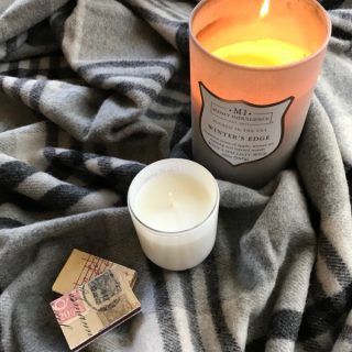 candle sitting on a plaid blanket
