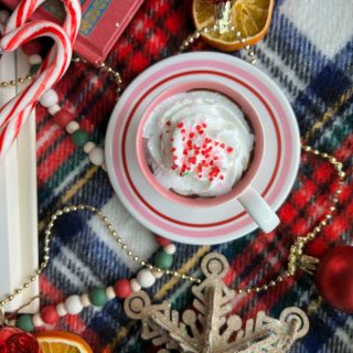 hot chocolate with whipped cream candy canes plaid flatlay