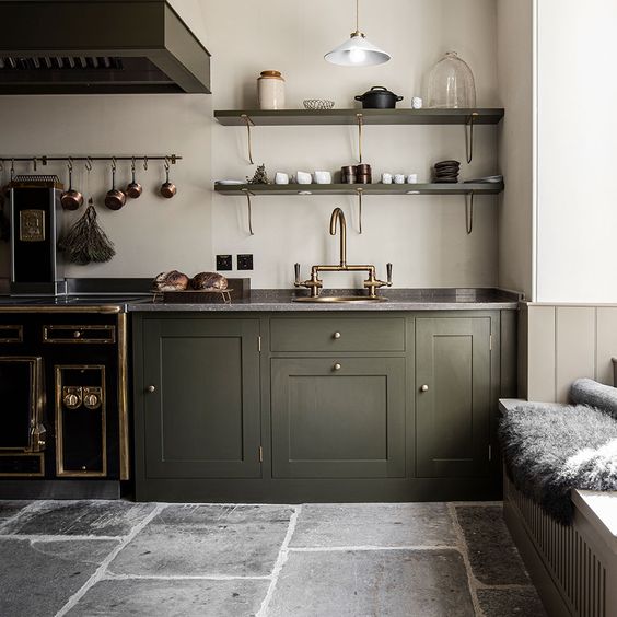 A Scottish kitchen with green cabinets and a stone floor. 