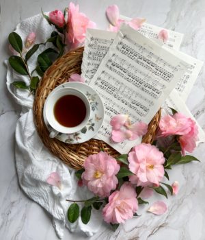 Friday Favorites Flatlay early spring with camellia flowers cup of tea and sheet music.